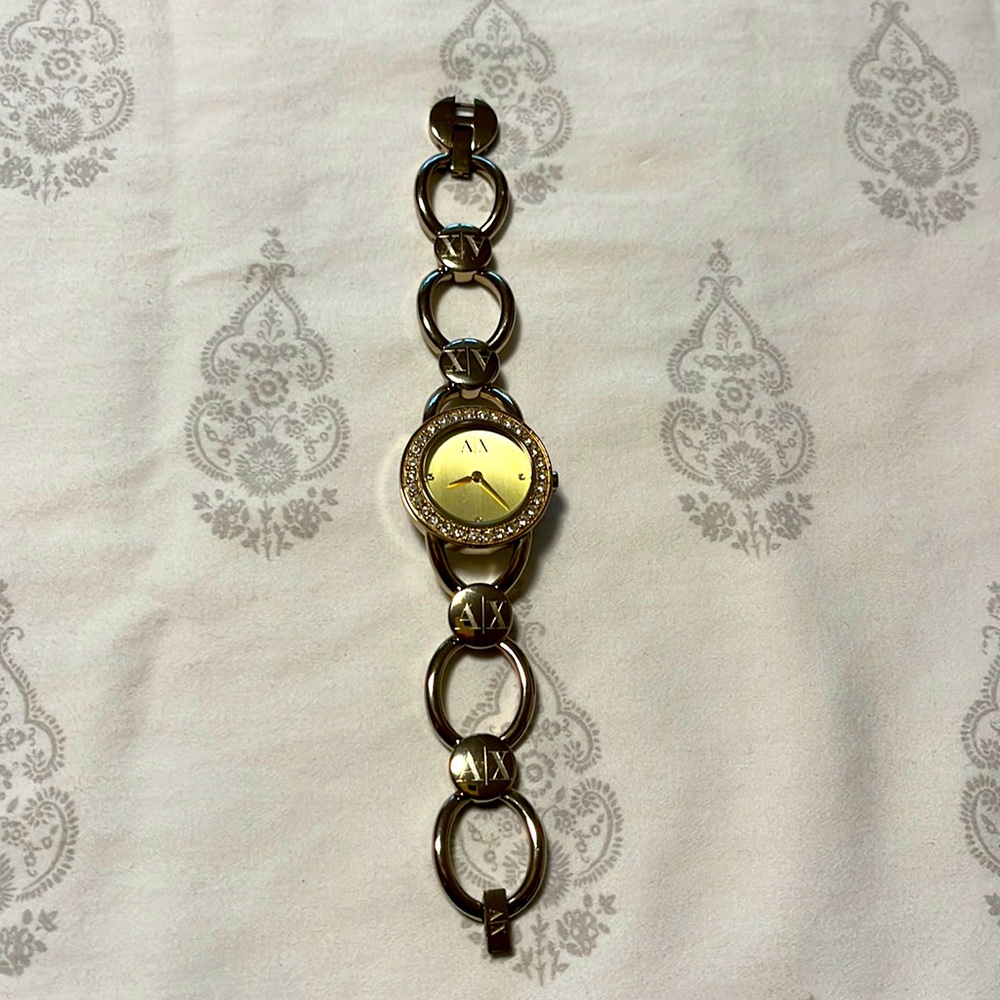 A|X Armani Exchange gold bracelet-style watch with stones surrounding the dial.